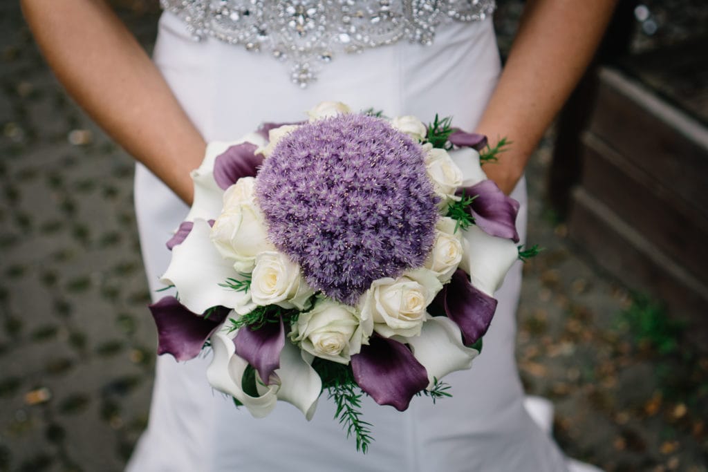 Kugelförmiger Brautstrauß mit Allium als zentrale Blüte und Blickfänger. Der lavendelfarbene und weiße Strauß überzeugt durch seine Einzigartigkeit.